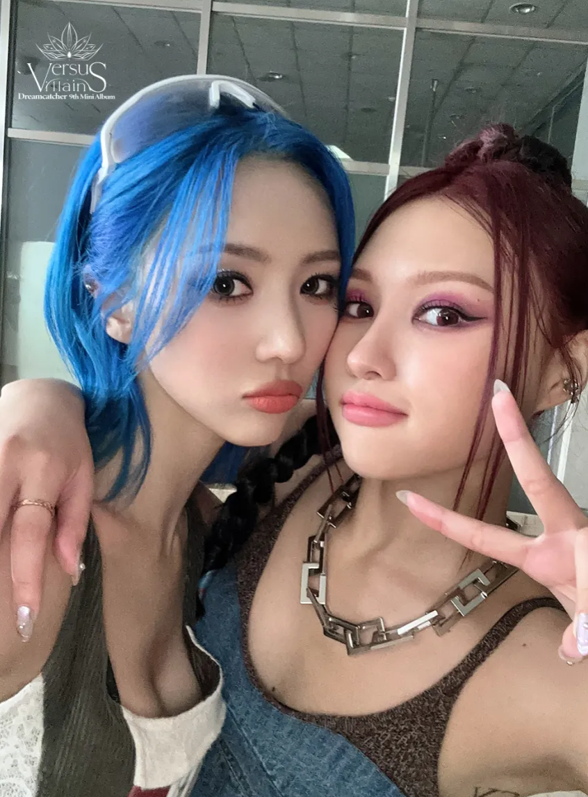 Blue-haired Yoohyeon and red-haired Siyeon post a quick selfie together during OOTD filming.