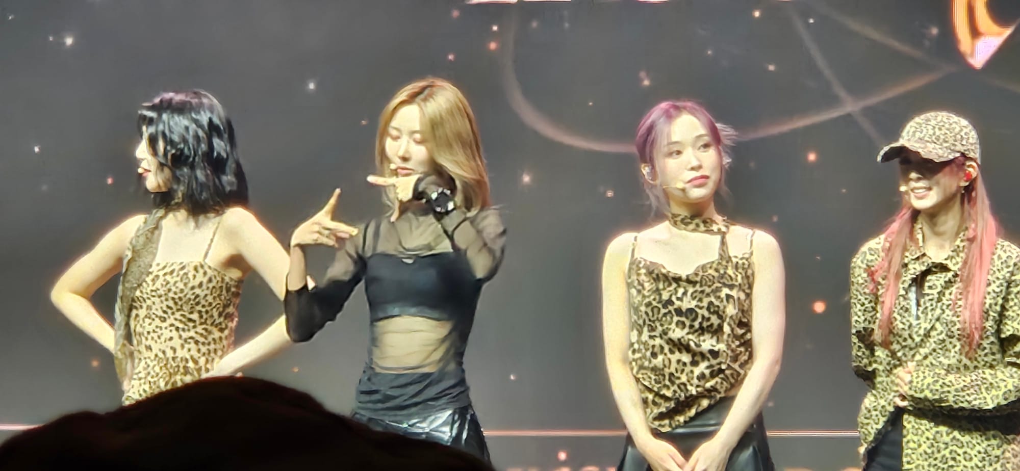 Dreamcatcher Yoohyeon miming making picture memories with fans as JiU, Gahyun, and Dami look at the audience.