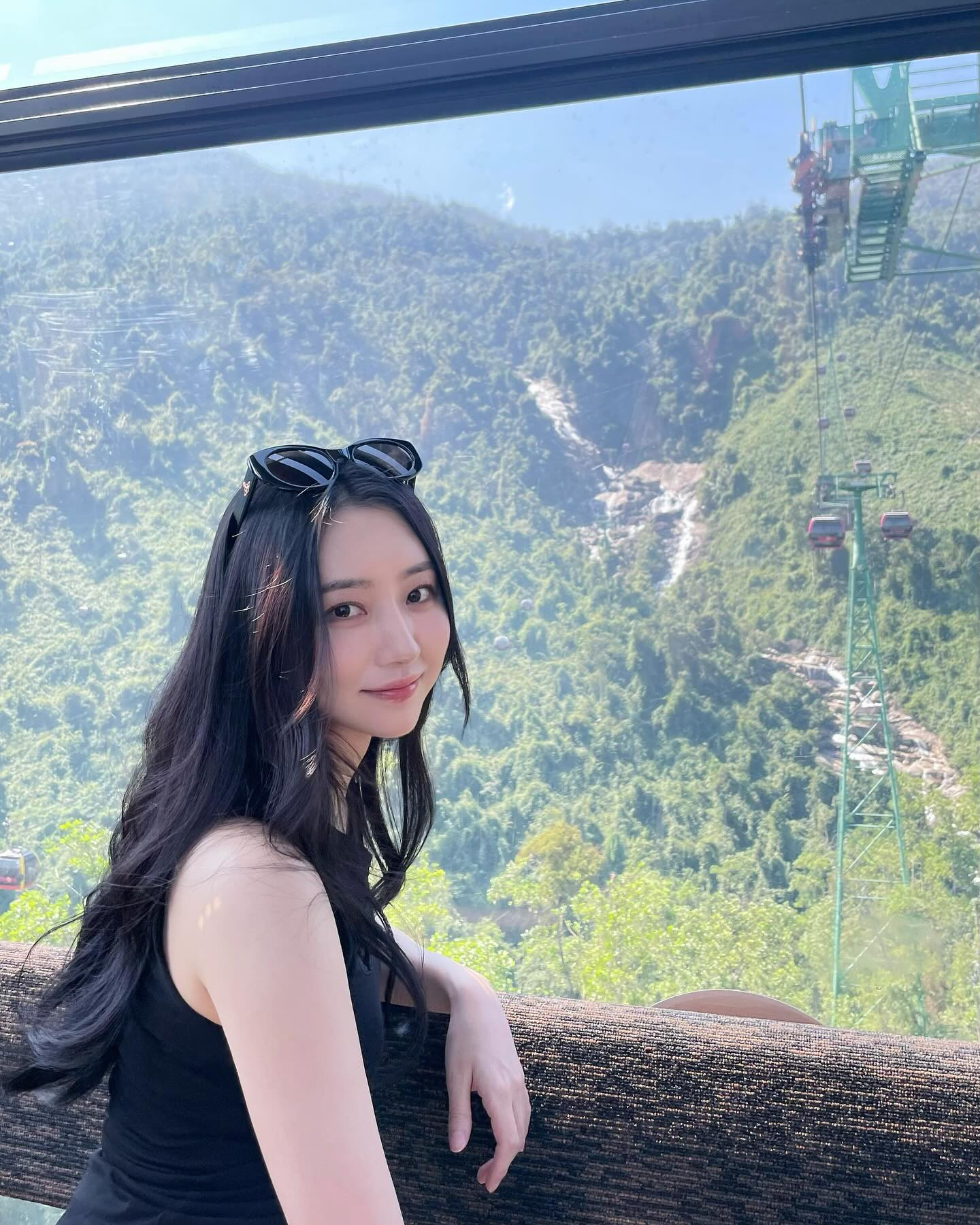 SuA smiling for the camera with a beaufiful green mountain range in the background.