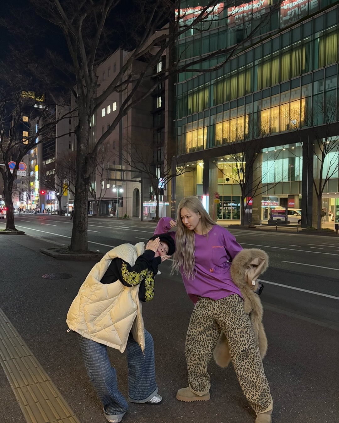 Siyeon and Handong posing in funny ways for the camera on the sidewalk.