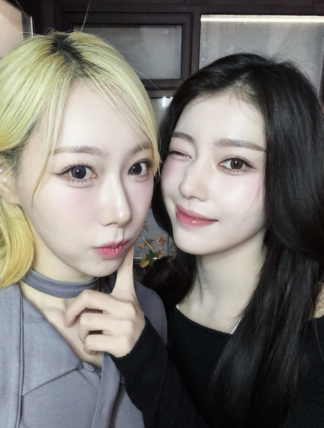 Handong puffing out her cheeks for Xiaoting to poke while she winks.
