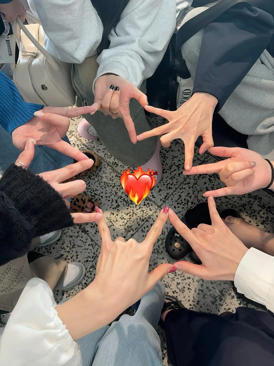 Group picture in a circle of Dreamcatcher members forming a star with their hands.