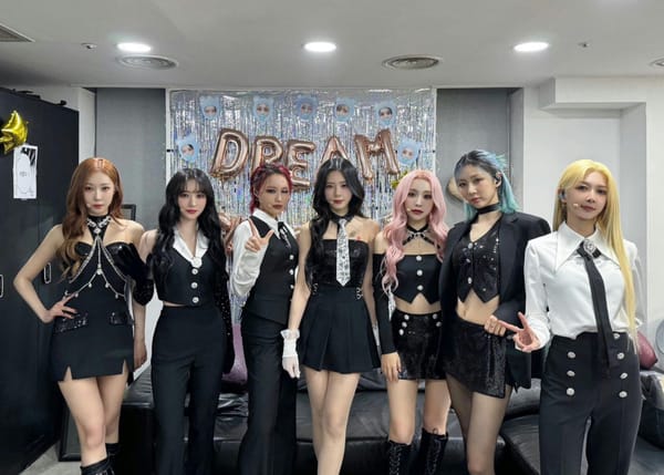 Dreamcatcher in black and white clothes, posing for a group picture in their waiting room.