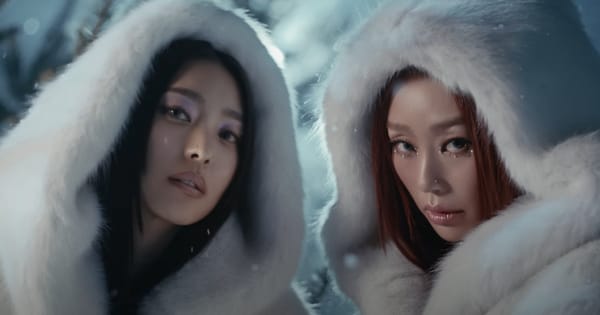SISTAR's Bora and Hyolyn glad in white fur hoods staring at the camera in a snow-filled field.