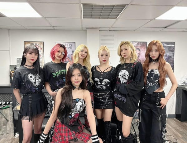 Dreamcatcher, dressed in black rock-style outfits, takes a photo in a London concert venue dressing room.