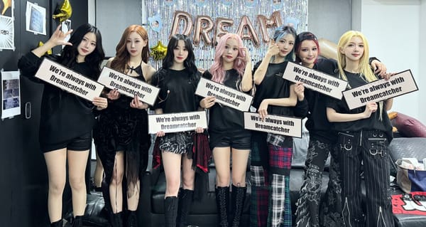 Dreamcatcher poses and smiles with banners saying "We're always with Dreamcatcher" for their Seoul concert
