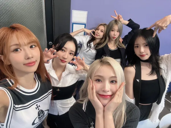 Dreamcatcher takes a group picture in black and white outfits backstage.