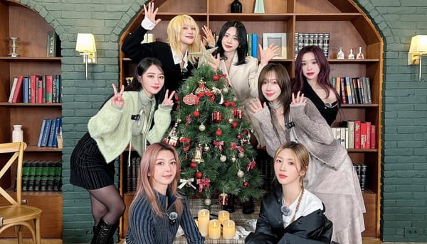 Dreamcatcher taking a picture with a Christmas tree with decorations, all smiling and waving for the camera.